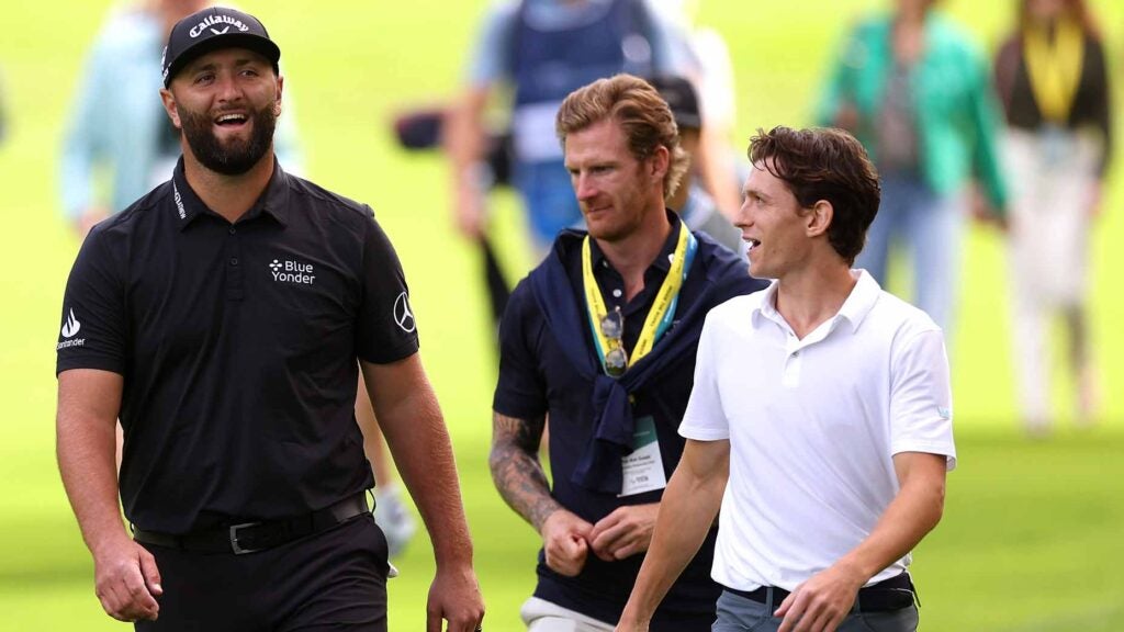 jon rahm laughs while talking with actor tom holland
