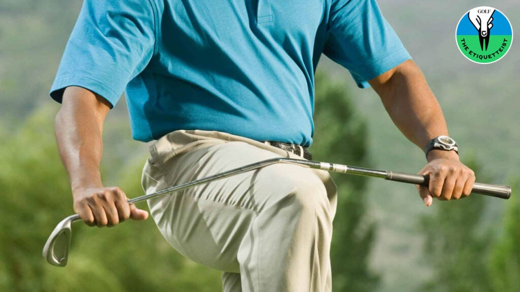 golfer snapping a golf club over his knee