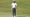 Joel Dahmen in a white shirt and blue pants stands on a putting green