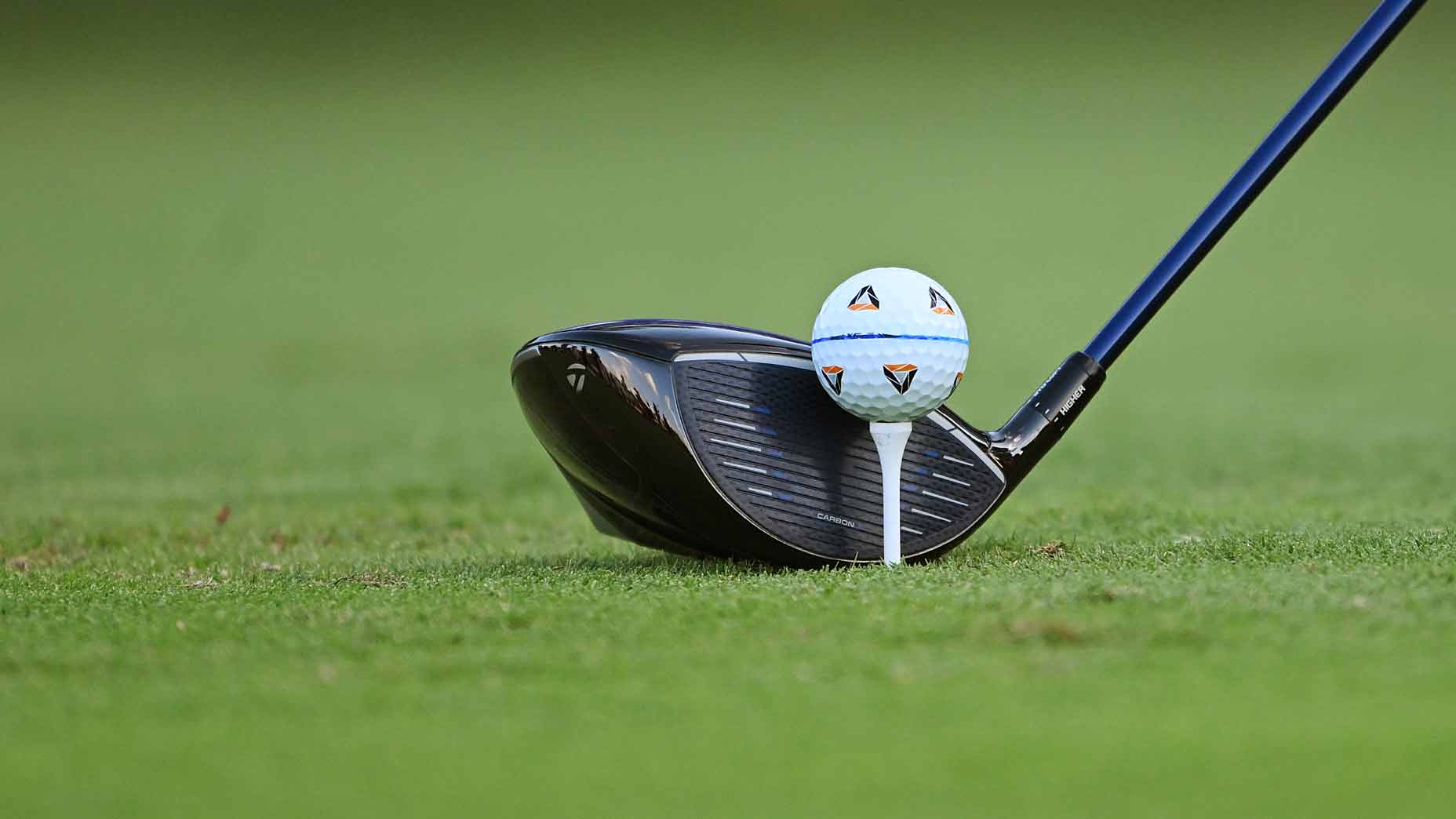 taylormade golf ball is teed up in front of a taylormade driver