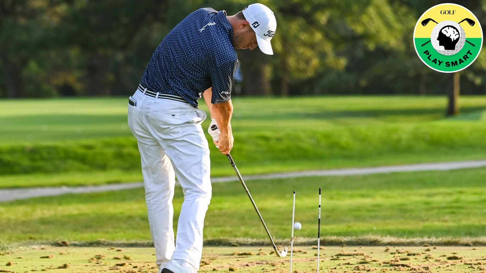 justin thomas hits golf balls on the range with alignment sticks in front of him