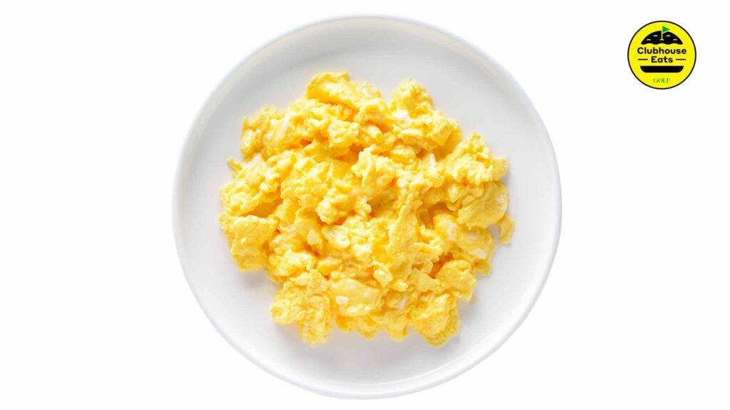 a photo of a scrambled eggs on a white plate with a logo in the top corner