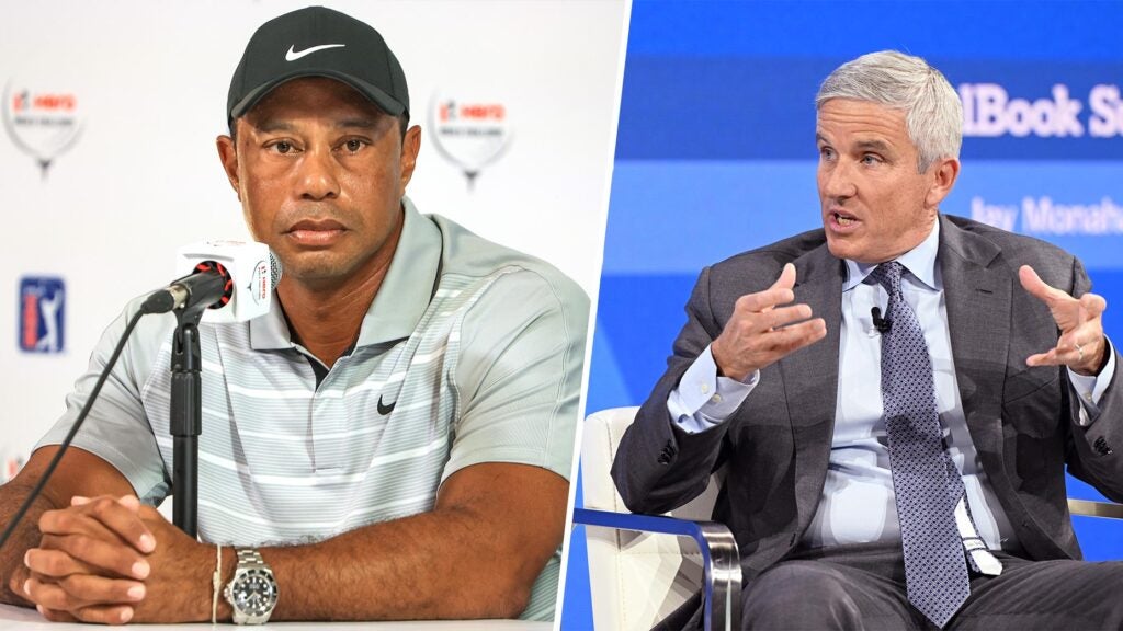 tiger woods sits in front of white podium, jay monahan speaks in suit at panel
