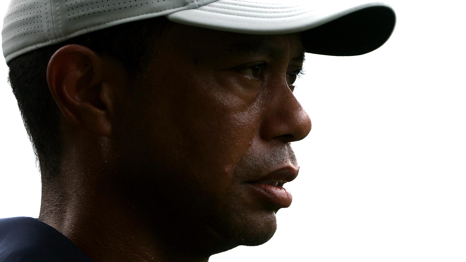 tiger woods stares off into the distance at the masters wearing a white hat