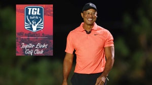 tiger woods smiles on the golf course