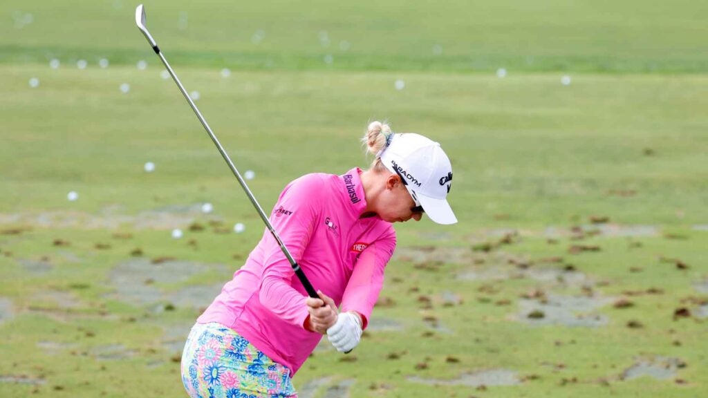 woman hitting golf balls on a driving range