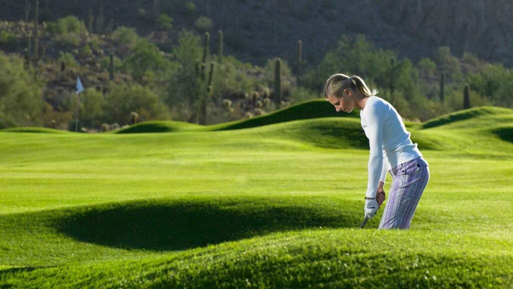 A woman hits a golf shot in Arizona, Gold Canyon Golf Resort