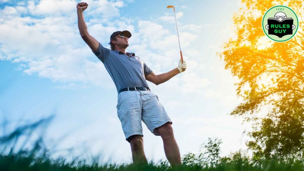 A golfer celebrating his shot with a dramatic sky behind.