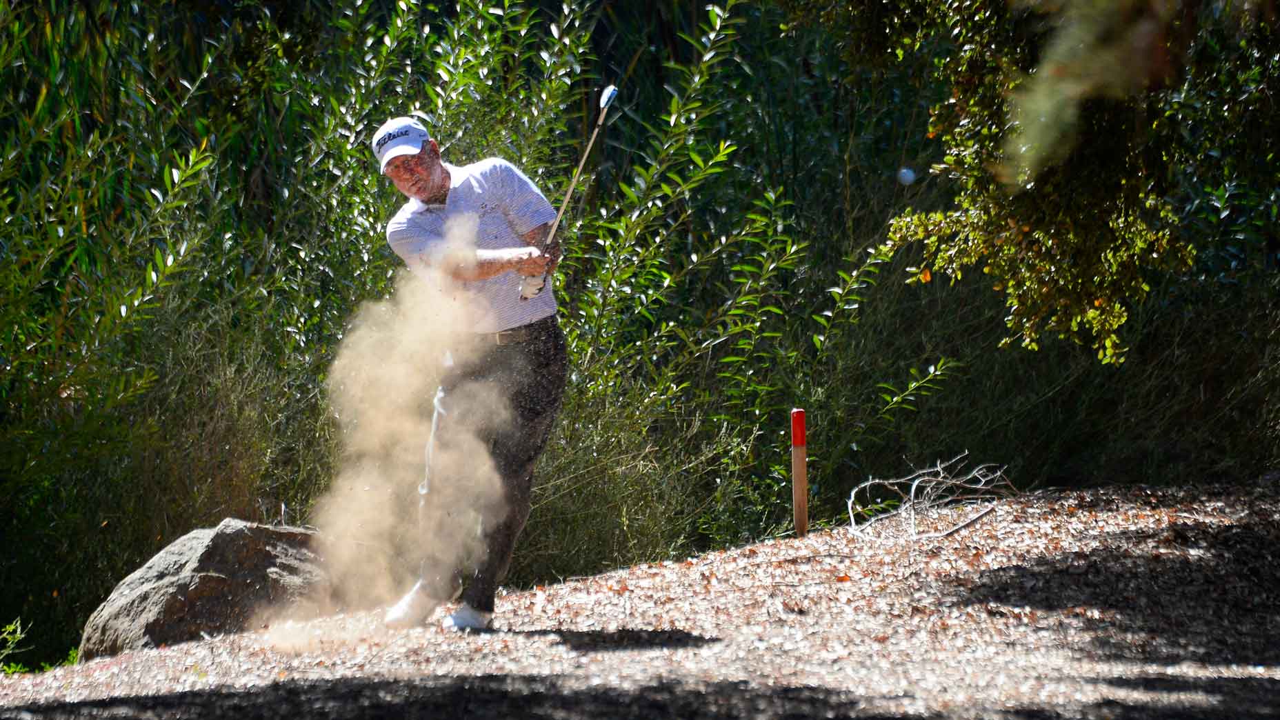 Pro golfer Jay Haas hits a shot out of a hazard on the first hole during the final round of the PGA Champions Tour 2018 Invesco QQQ Championship at the Sherwood Country Club on October 28, 2018