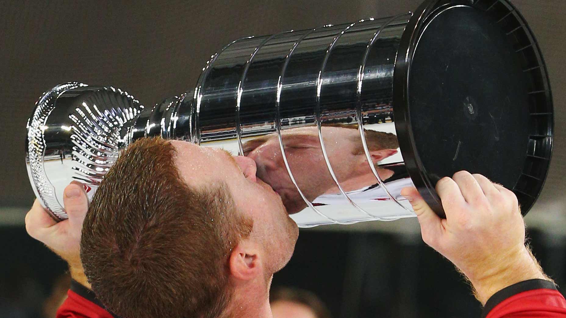 Mike Commodore kisses the Ice Hockey Classic trophy.