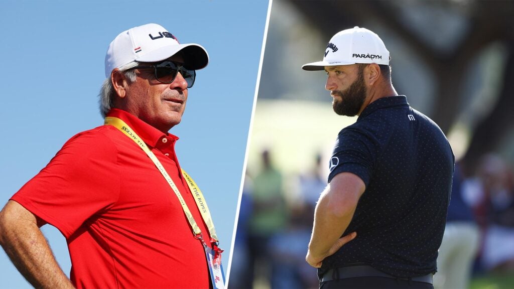 fred couples stands in a red shirt at the Ryder Cup separated from Jon Rahm standing in a navy shirt.