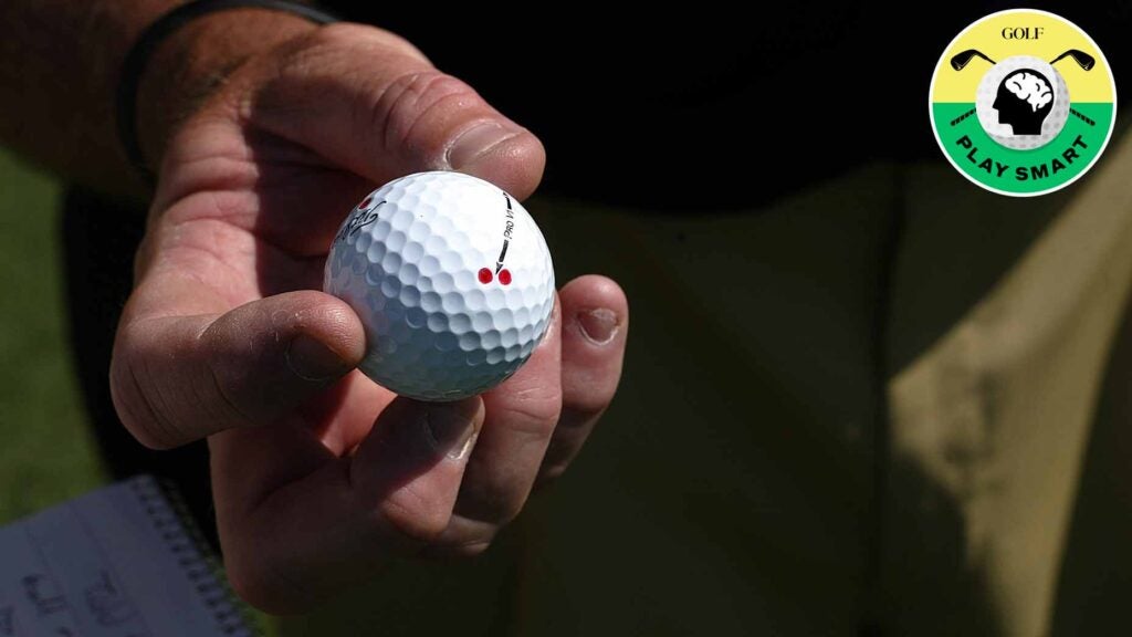 person holds golf ball with dots on it in their hands