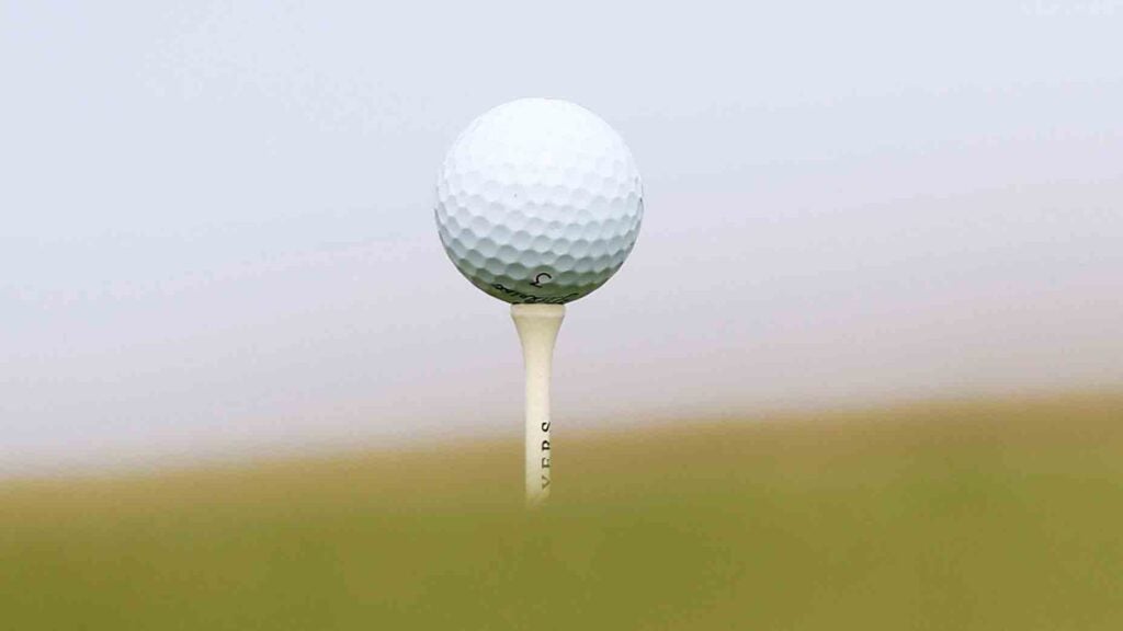 Golf ball sitting on a golf tee on a golf course