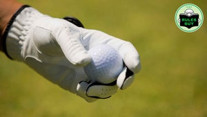 Close-up of a person's hand holding a golf ball