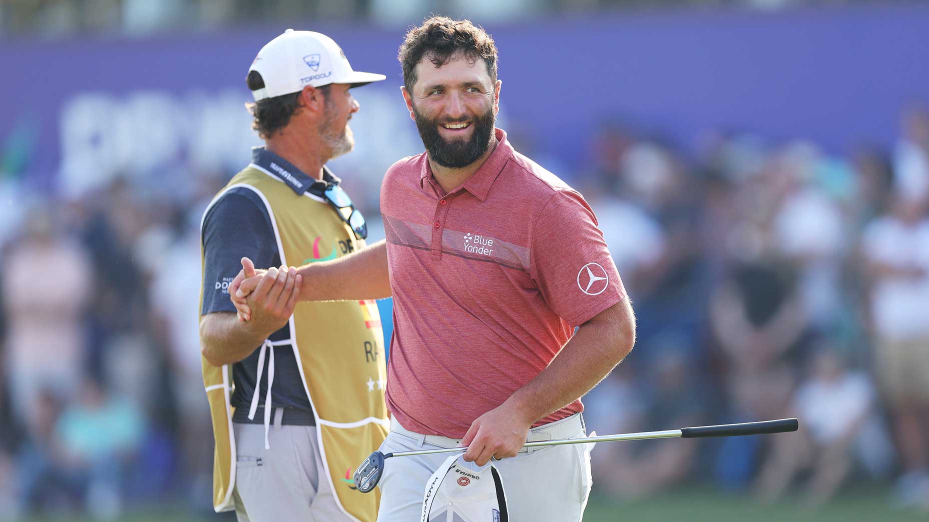 Jon Rahm greets his caddie on green at 2023 DP World Tour Championship