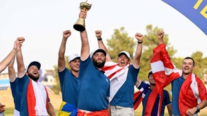 jon rahm celebrates with the ryder cup in italy in 2023 as his teammates look on
