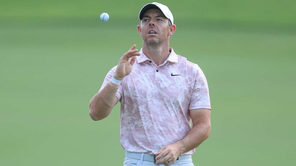 Rory McIlroy tosses golf ball in air during 2023 DP World Tour Championship