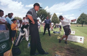Tiger Woods watches a golfer take a swing during a Tiger Woods Junior Golf Clinics at Hiawatha Golf Course on July 25, 1999.