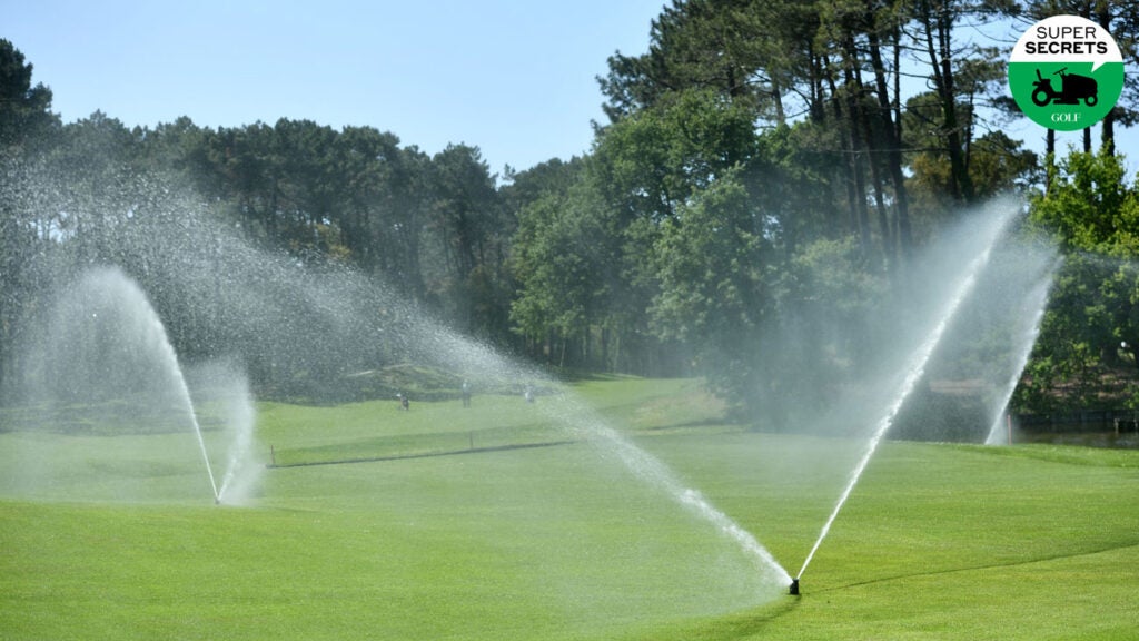 sprinklers watering a golf course fairway