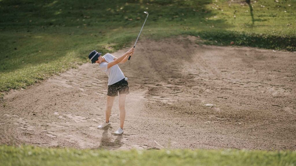 woman hitting long bunker shot