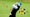 golfer hitting balls on range with yardage markers