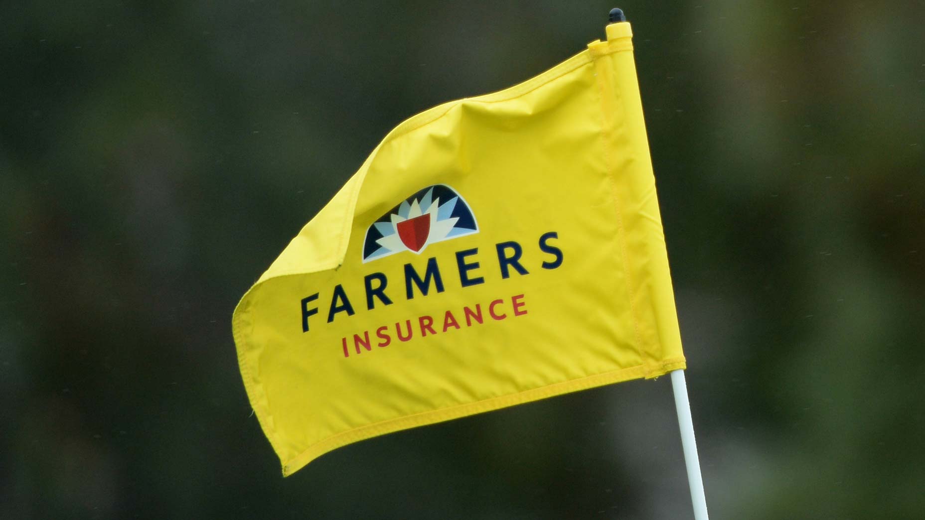 A yellow flag for the Farmers Insurance Open golf tournament waves in the wind
