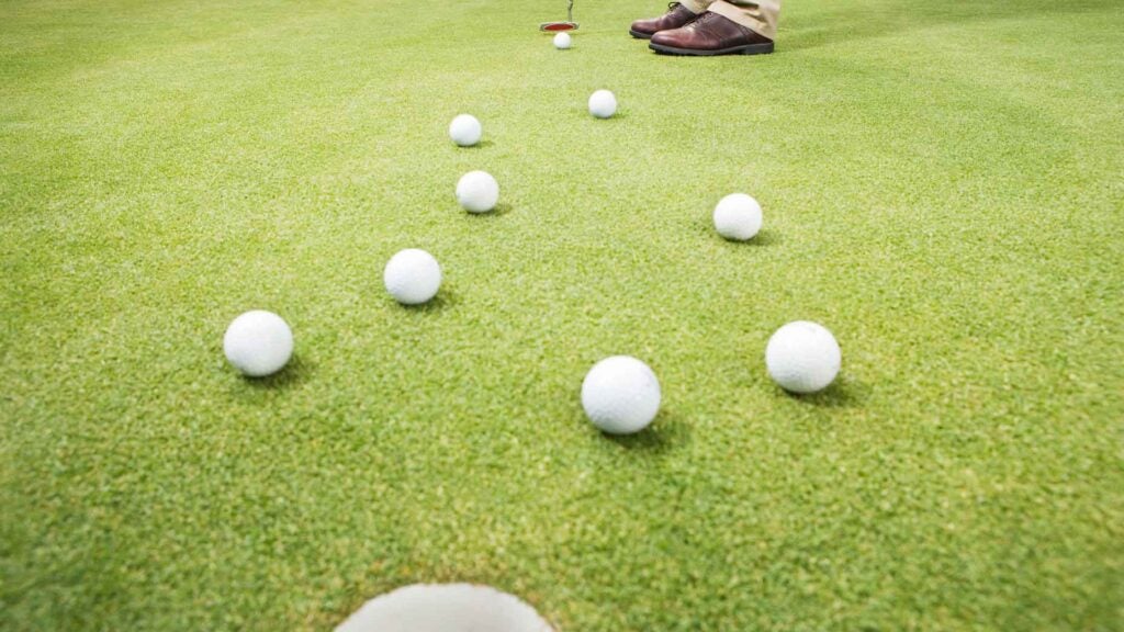 golfer with multiple balls on putting green