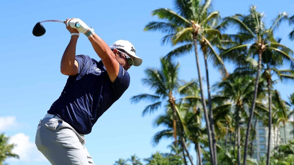 Pro golfer Hideki Matsuyama hits drive in front of palm trees at 2024 Sony Open in Hawaii
