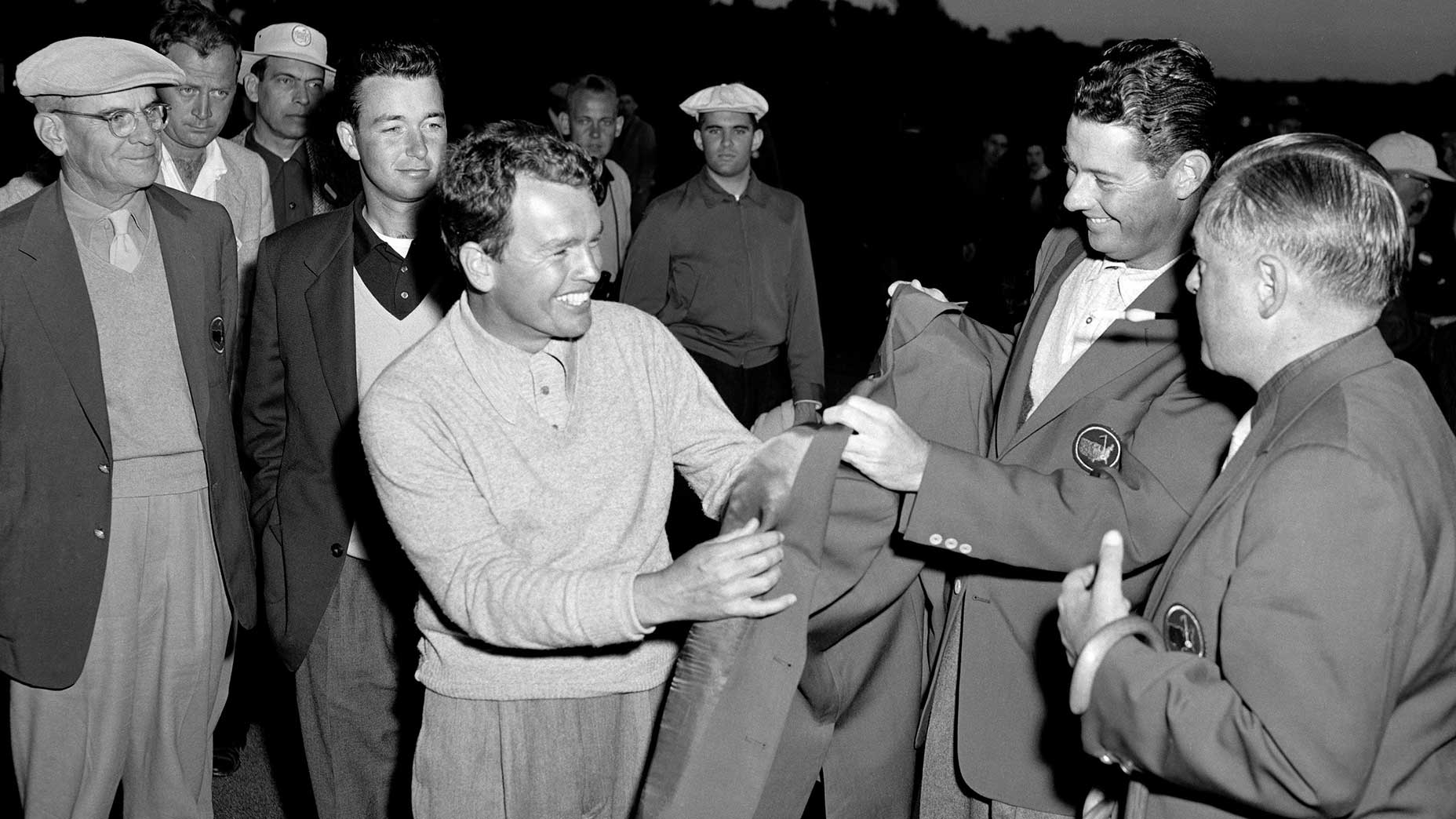 Jackie Burke Jr. receives the green jacket from Cary Middlecoff after winning the 1956 Masters at Augusta National Golf Club in Augusta, Georgia on April 8, 1956.