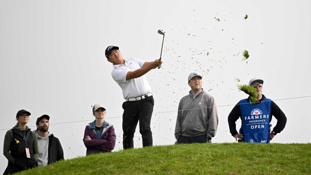 Kevin Yu hits shot from rough surrounded by fans at 2024 Farmers Insurance Open