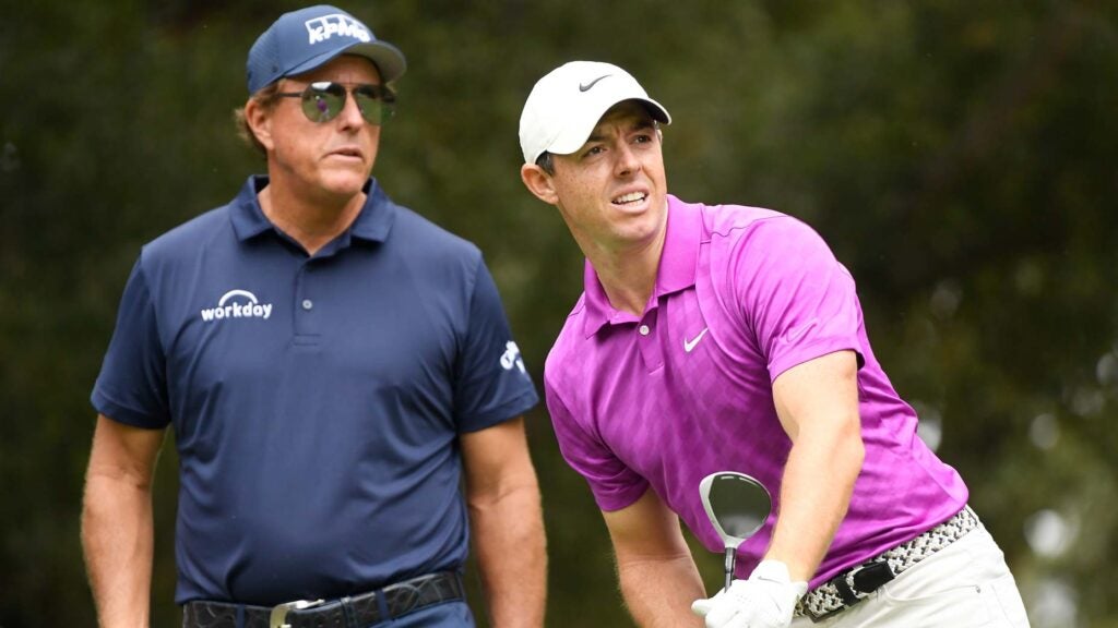 Rory McIlroy picks up tee after drive as Phil Mickelson watches at 2020 Zozo Championship