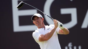 Rory McIlroy hits drive in front of sign at 2024 Dubai Desert Classic