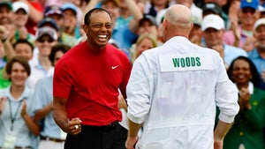 Tiger Woods and caddie Joe LaCava celebrate winning the Masters at Augusta National Golf Club on April 14, 2019.