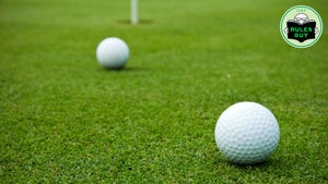 Two golf balls on the putting green. Shallow DOF. The ball in the foreground is in focus