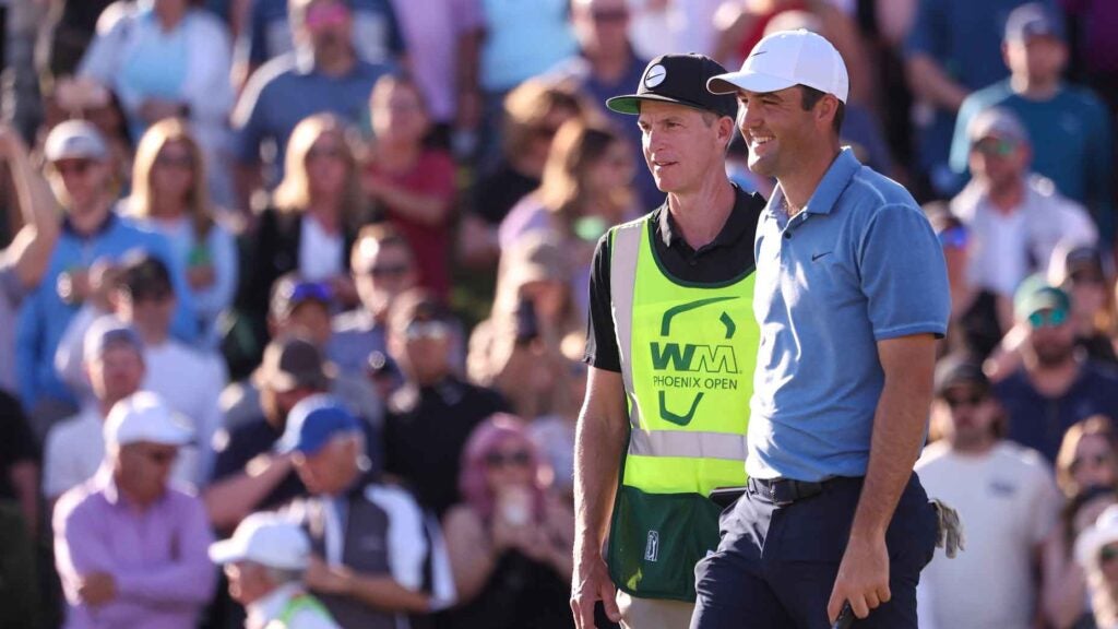 Scottie Scheffler of the United States and caddie Ted Scott smile on the 18th green during the final round of the WM Phoenix Open at TPC Scottsdale on February 12, 2023 in Scottsdale, Arizona.
