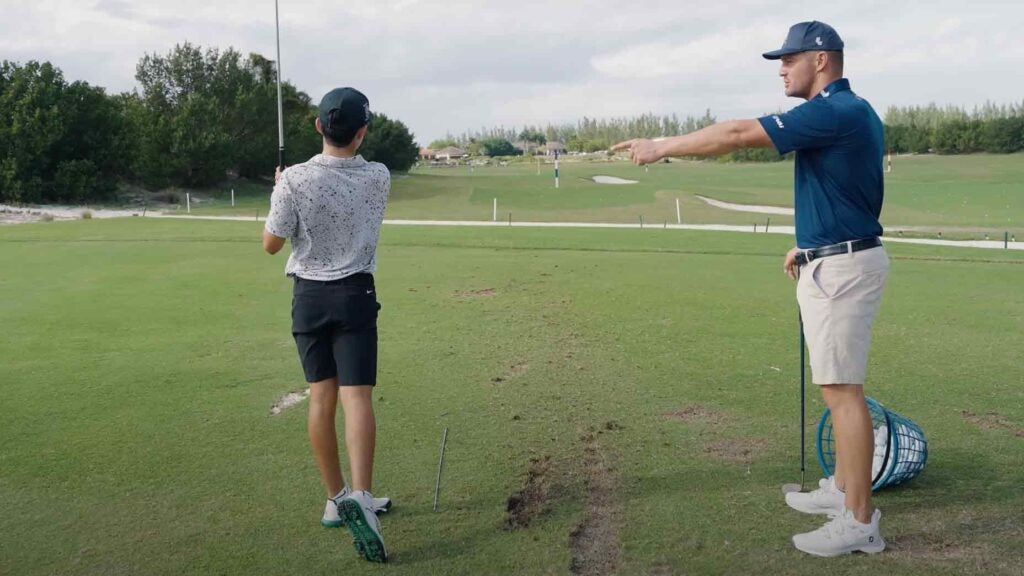 Bryson DeChambeau instructs junior golfer on driving range