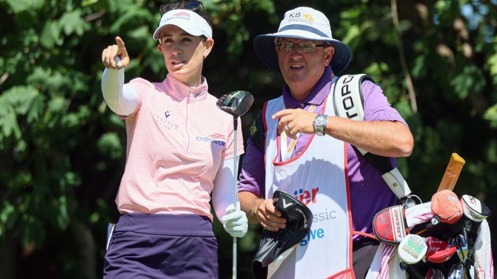 cheyenne knight stands next to her caddie and points into the distancw at the meijer LPGA