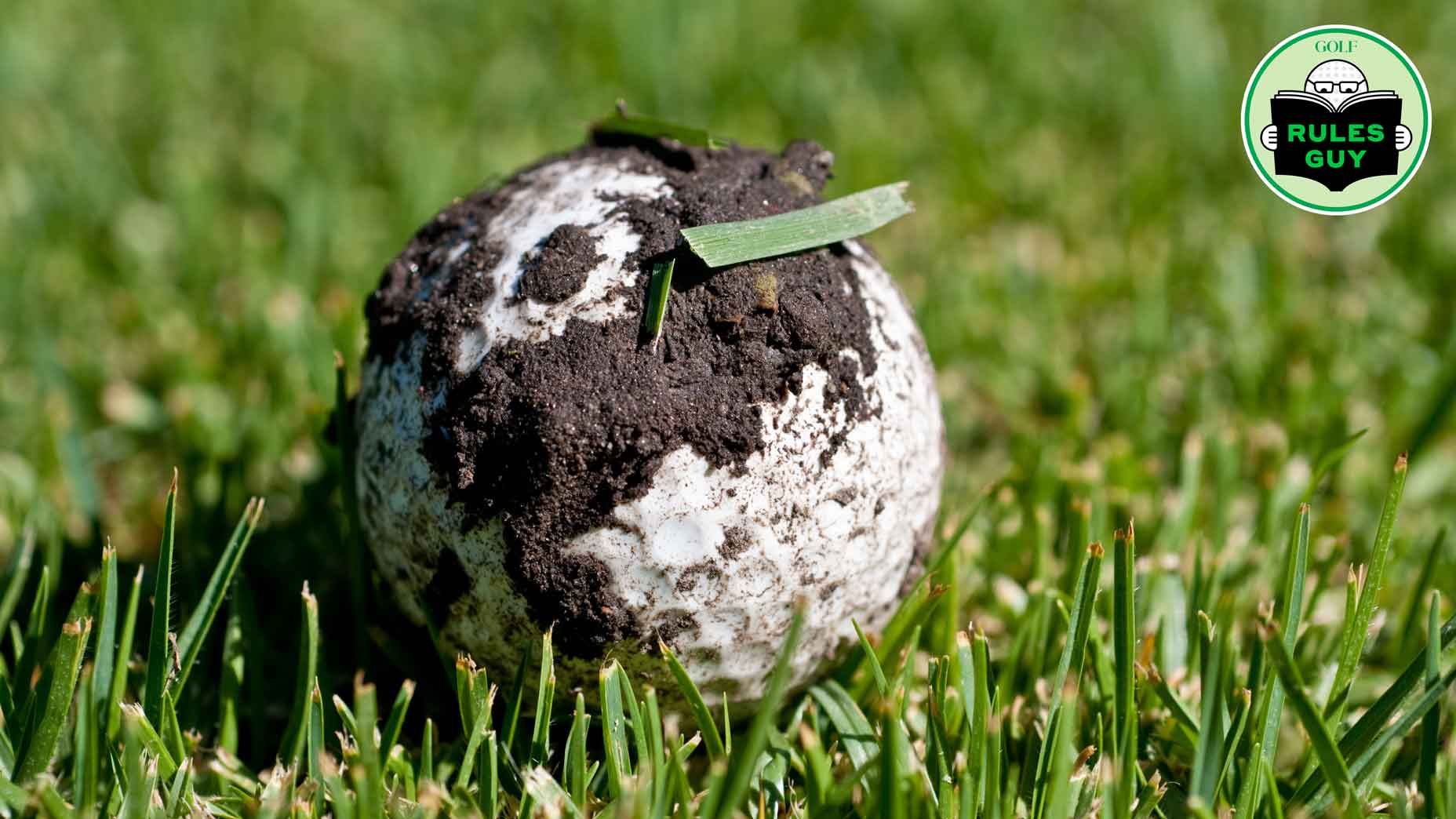 Golf ball that is covered with dirt and grass, possibly from being hit into the rough