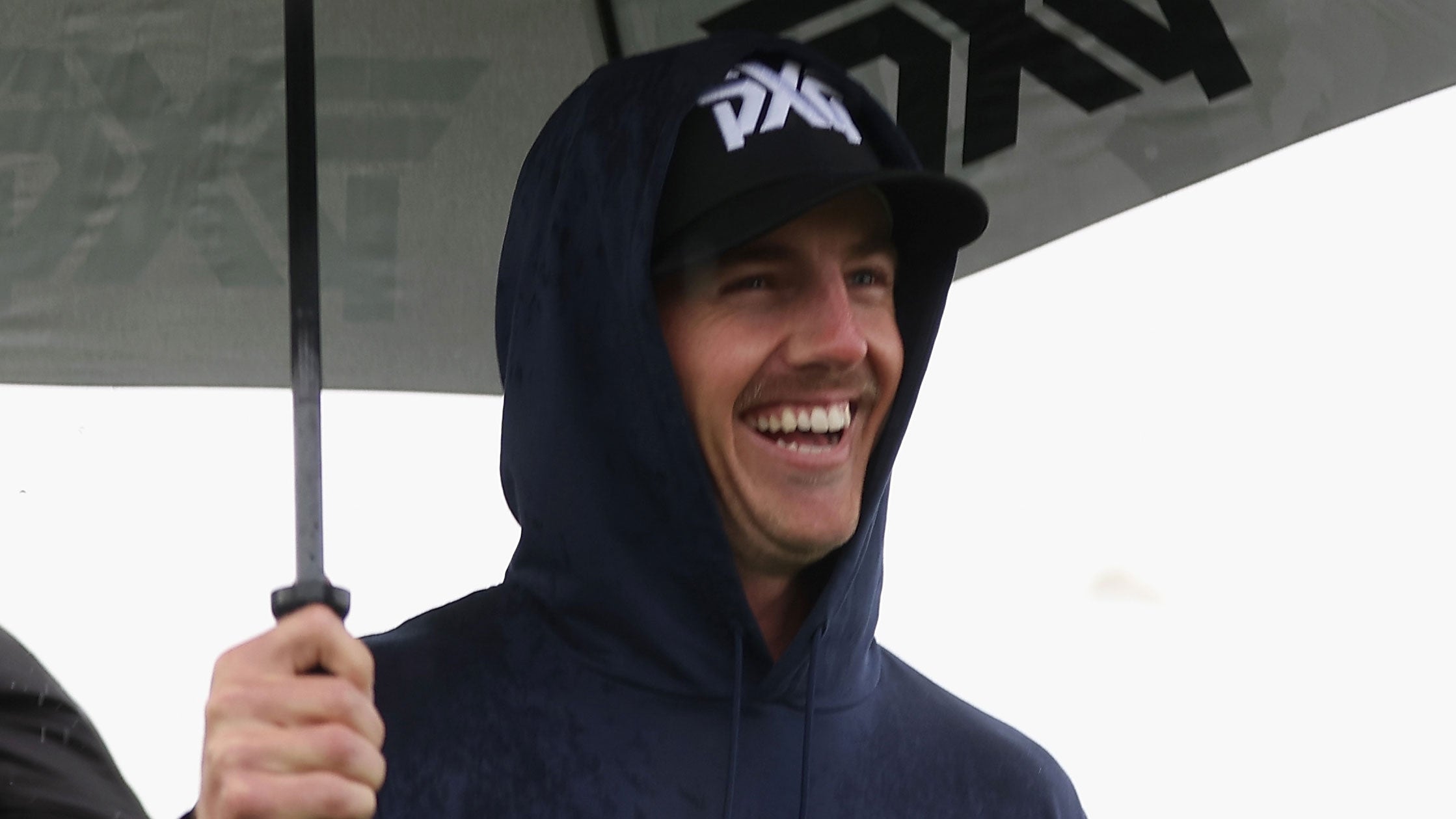 Jake Knapp walks with an umbrella during the Pro-am to the WM Phoenix Open at TPC Scottsdale