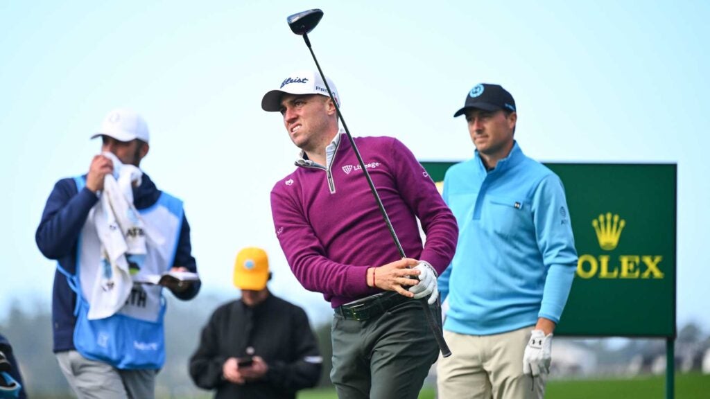 Justin Thomas hits tee shot at 2024 AT&T Pebble Beach Pro-Am with Jordan Spieth looking on