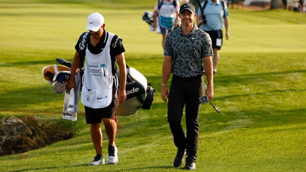Rory McIlroy smiles while walking with his caddie at 2024 Cognizant Classic