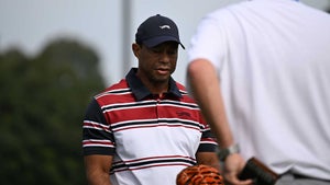 tiger woods grimaces at genesis invitational in red striped shirt