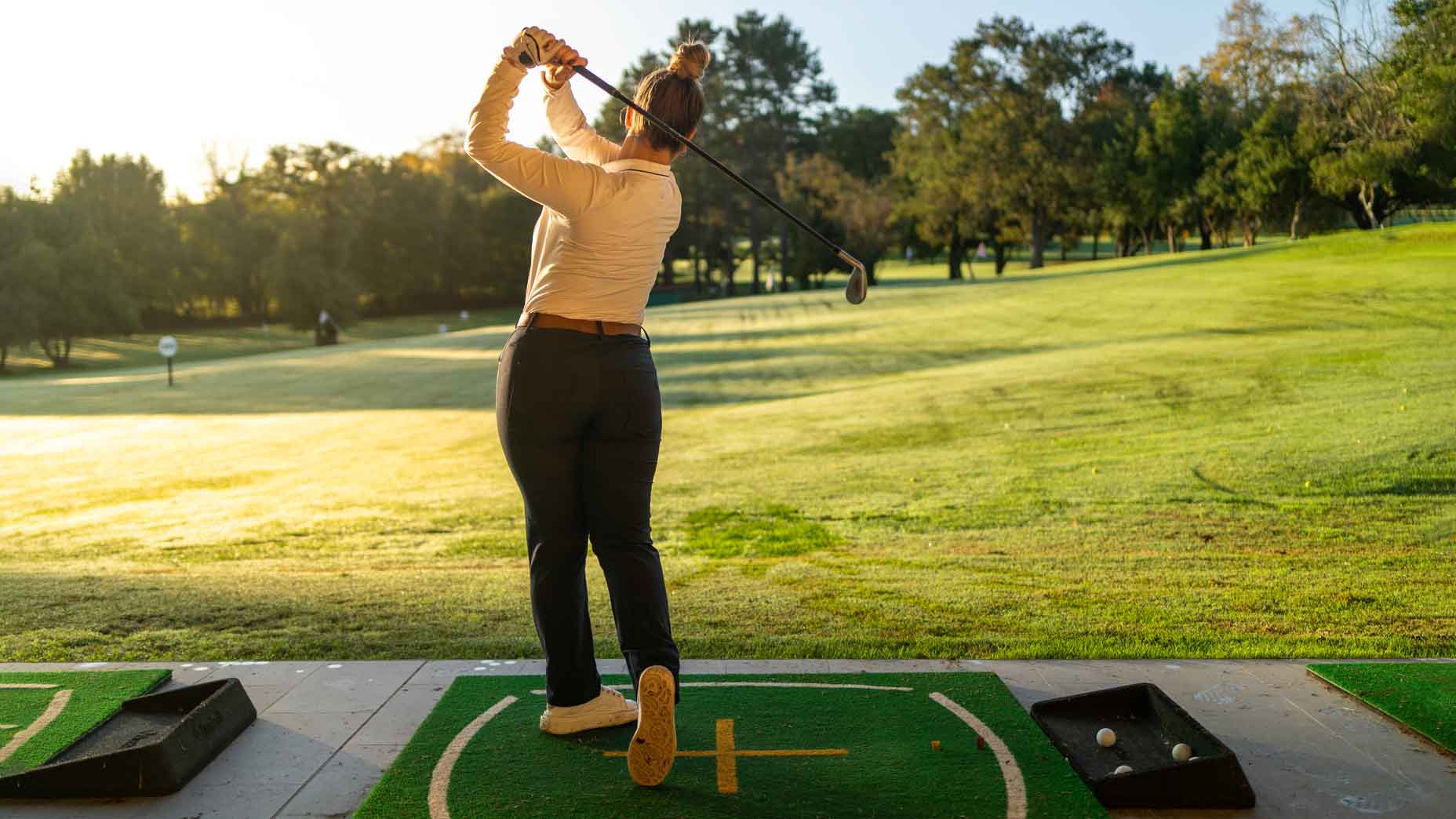 Female golfer hitting drive on golf course
