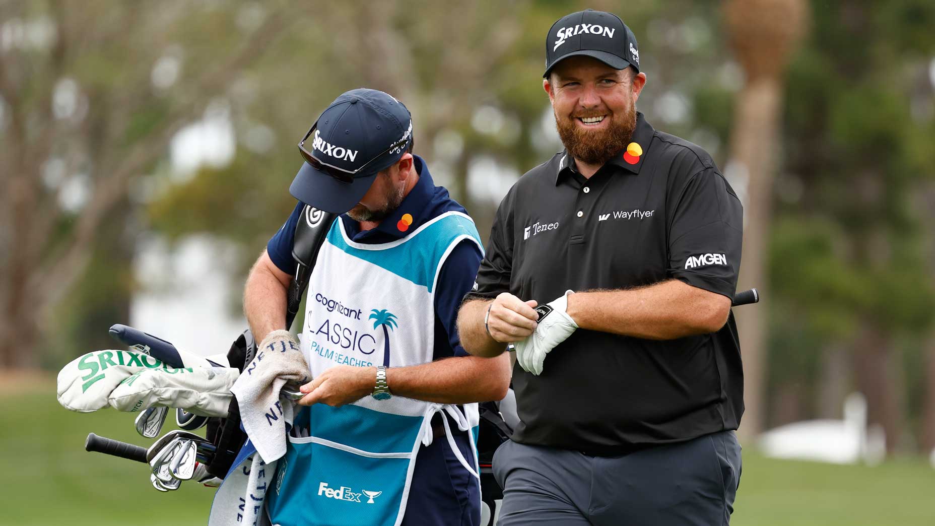 Shane Lowry smiles next to his caddie at the Cognizant Classic.