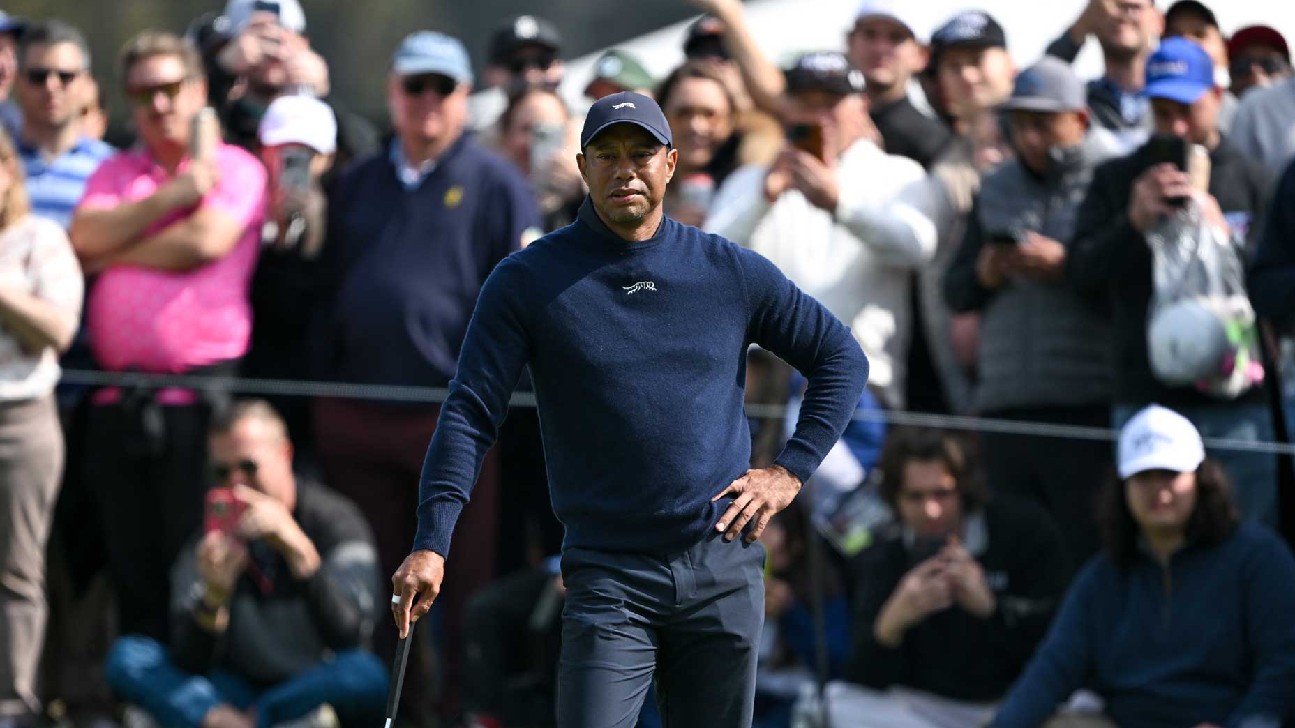 Tiger Woods stands on a green at the Genesis Invitational.