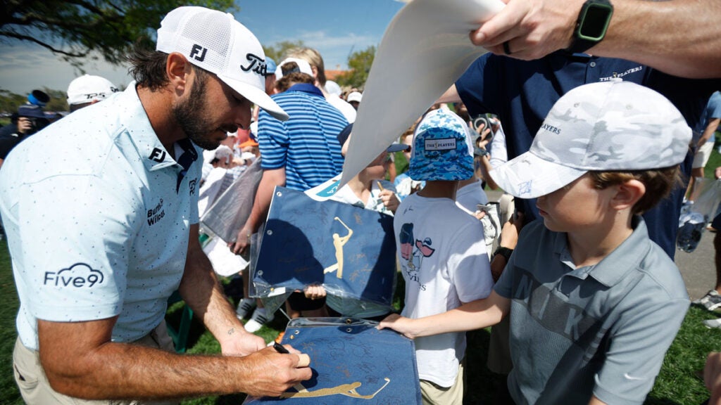 Max Homa of the United States signs autographs on the ninth green during a practice round prior to THE PLAYERS Championship on the Stadium Course at TPC Sawgrass on March 13, 2024 in Ponte Vedra Beach, Florida