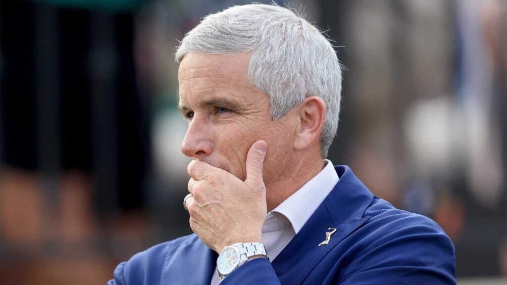 jay Monahan holds face from Players Championship winner's cerermony