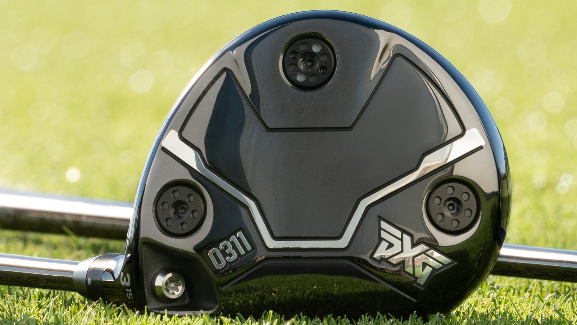 A pxg 0311 black ops fairway wood laying on grass.