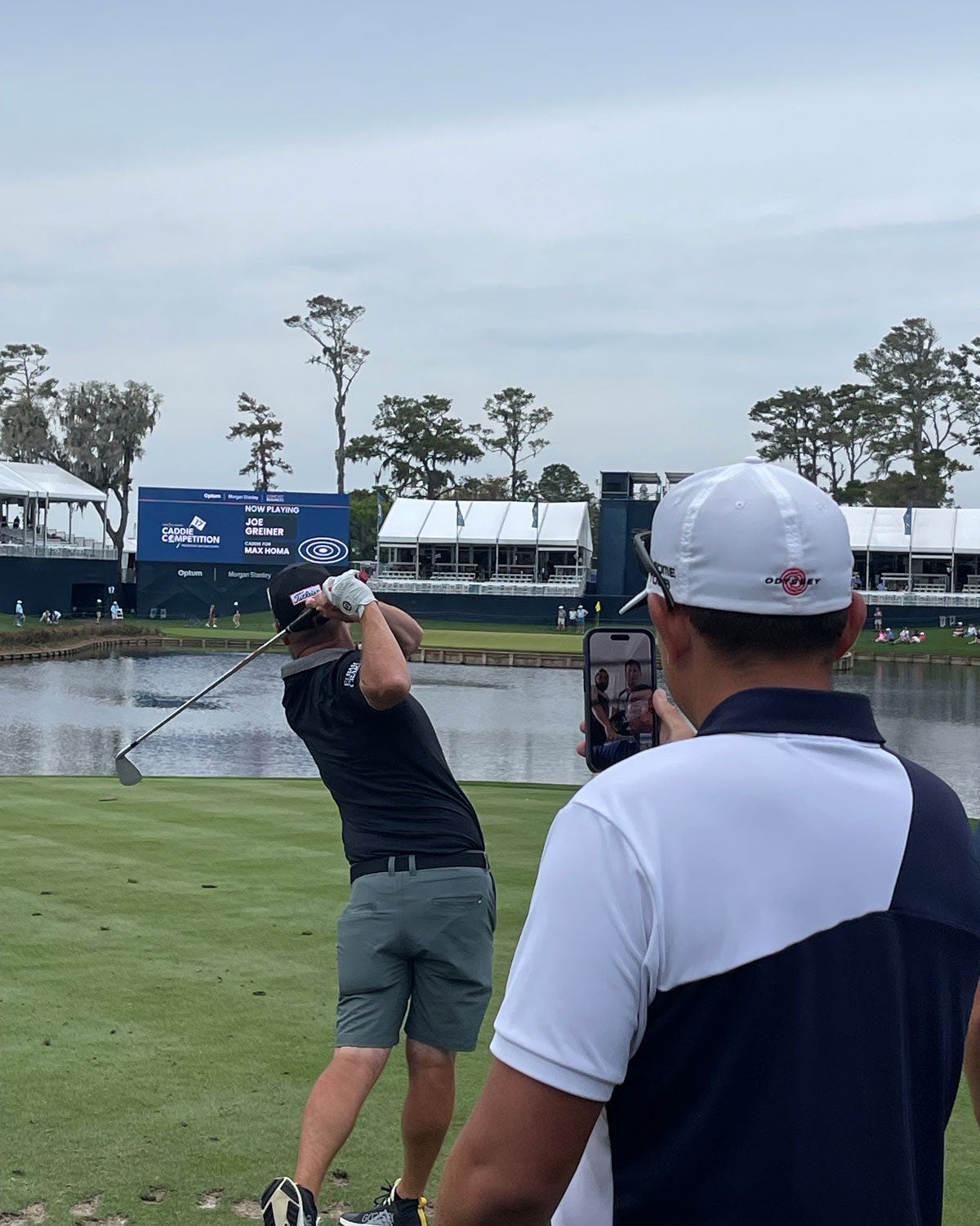 Austin Kaiser, caddie for Xander Schauffele, watches Joe Greiner, caddie for Max Homa, tee it up.