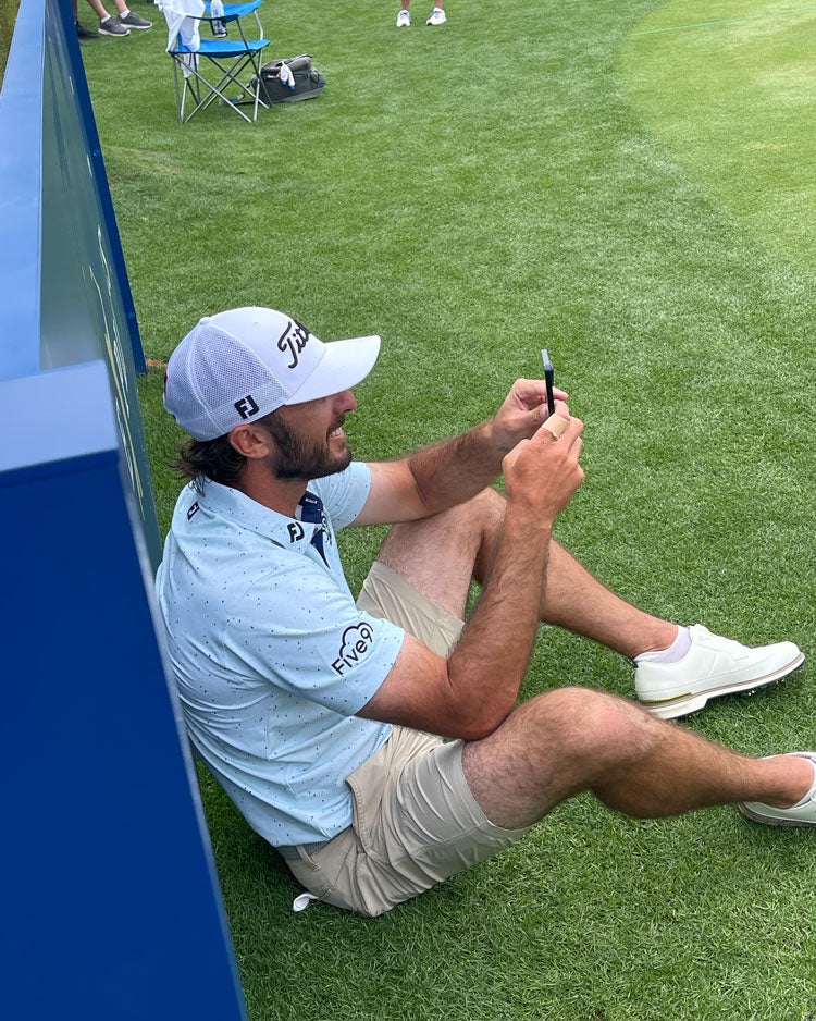 Max Homa watches his caddie, Joe Greiner, tee it up.